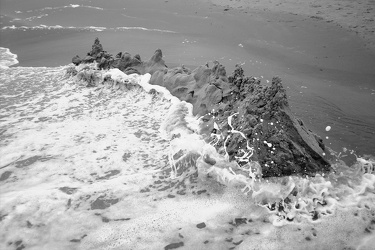 Sand castle being reclaimed by the waves