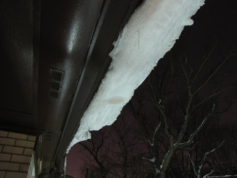 Snow beyond edge of roof