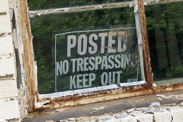 Posted No Trespassing in window of abandoned motel