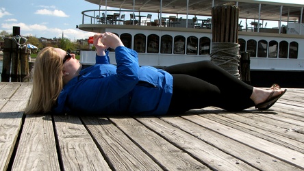 Woman lying on a dock to take a photo