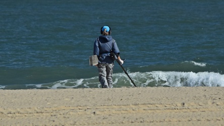 Person using metal detector on beach [02]