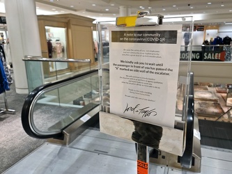 Social distancing signage in front of an escalator