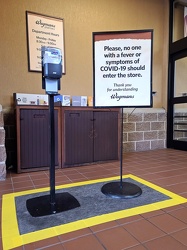 Hand sanitizer and COVID sign at Wegmans