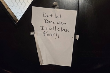 Sign advising not to let the elevator door slam