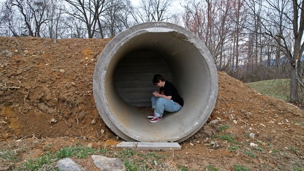 Elyse sits in a concrete pipe