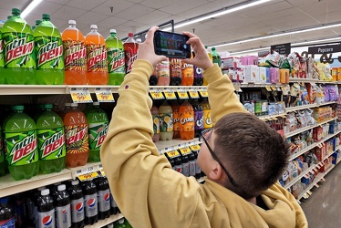 Elyse photographs bottles of soda