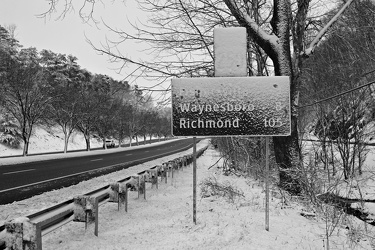 Snow-covered mileage sign on US 250