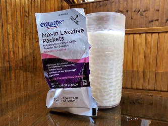 Glass of milk with a laxative packet