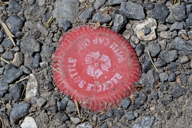 Bottle cap embedded in gravel [01]