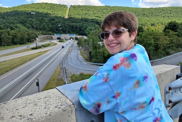 Elyse smiles on a bridge overlooking the Kittatinny Mountain Tunnel