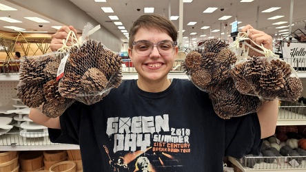 Elyse holds up two bags of stinky pinecones