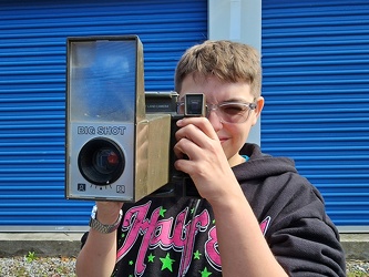 Elyse holds up a Polaroid Big Shot