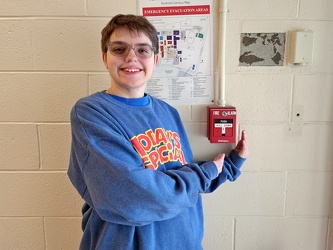 Elyse poses with a fire alarm pull station