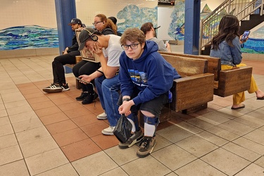 People wait on benches at Delancey Street station