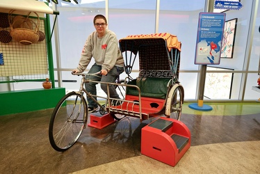 Elyse sits on a cycle rickshaw