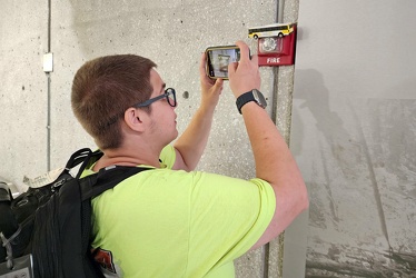 Elyse photographs a low-mounted fire alarm strobe