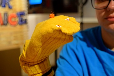 Elyse holds up a sock puppet