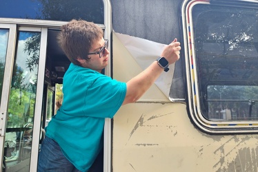 Elyse peels a section of wrap off of former CARTA bus 3426