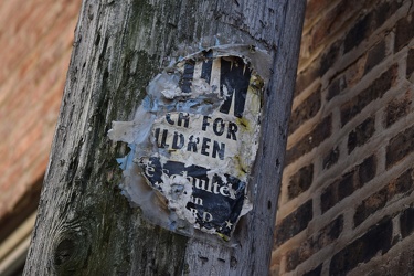 Weathered poster on a utility pole