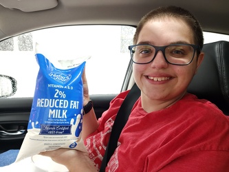 Elyse holds up a bag of milk