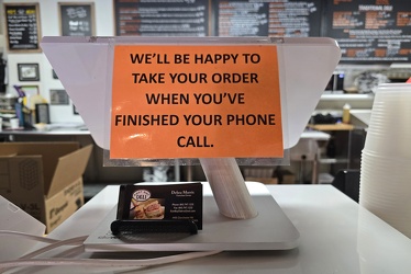 Sign regarding phone calls at East Bay Deli