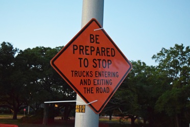 Orange warning sign zip-tied to a lamppost